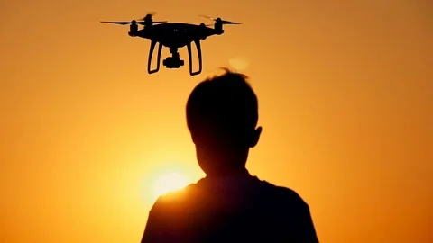 Drone flies from the hands of the boy at sunset Stock Footage