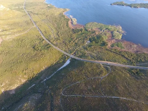 Drone flies high above winding road in Hermanus, South Africa Vídeo Stock 79708700