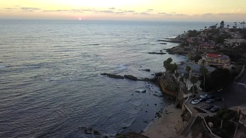 Drone flies high over oceanfront mansions with La Jolla background at sunset Stock Footage 97185011