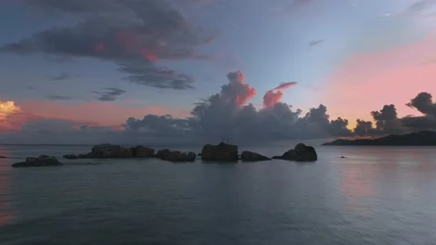 A drone flies at high speed along the ocean at sunset in the Seychelles. Stock Footage 154598940