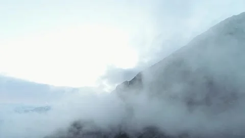 Drone flies high through the fluffy clouds on high attitude Mountains. Stock Footage 136378449