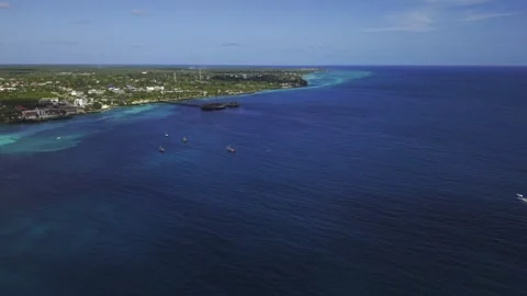 Drone flies inland over deep water toward resort with long wooden pier Stock-Footage 346470804
