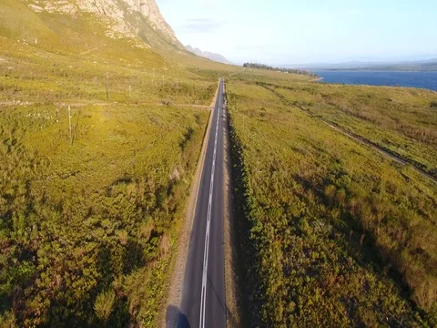Drone flies low above winding road in Hermanus, South Africa 스톡 동영상 79709218