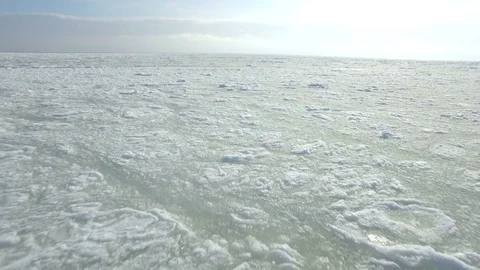 Drone flies low and backwards over the frozen Black Sea Stock Footage 72586468