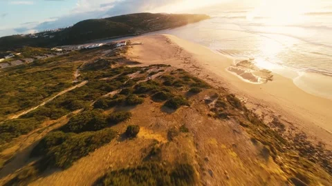 Drone flies low over beach dunes at golden hour Stock Footage 340914423