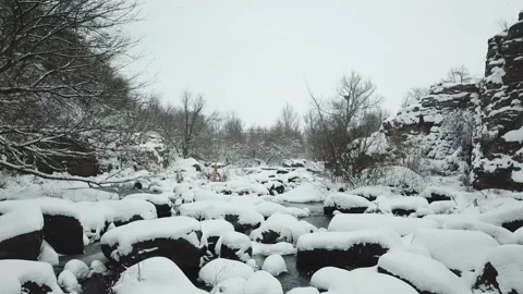 The drone flies low over a mountain river in winter. Video stock 147626876
