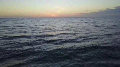 Drone flies low over ocean during sunset 스톡 동영상 244822816