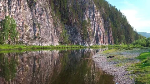 A drone flies low over the river towards the opposite rocky shore. Vidéo 116605846
