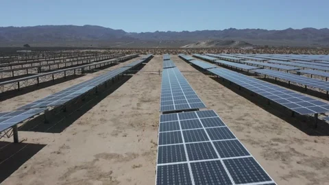 Drone flies low over solar panels in desert - Shot 4K Stock Footage 150649391