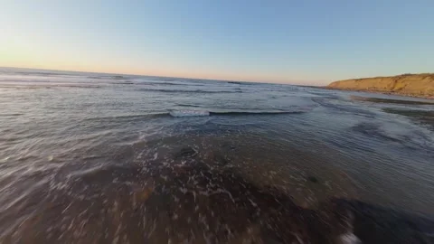 Drone flies low over tide pools, capturing sunset reflections Video stock 344561066
