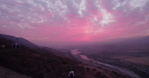 The drone flies next to the cabins of the funicular in the mountains, next to a Stock Footage 248342681