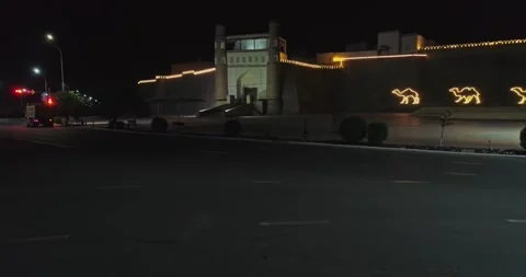 A drone flies at night over the illuminated main gate of the ancient complex Ark Stock Footage 271173946