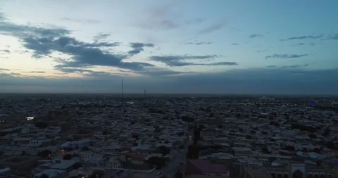 A drone flies over an ancient complex Lyab-i Hauz surrounded by houses in old Stock Footage 308009087