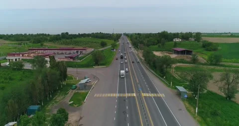Drone flies over an asphalt road with passing cars. Stock Footage 310716830