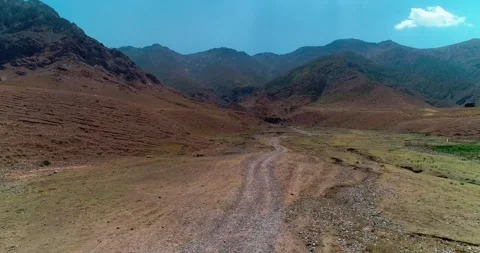 A drone flies over the bed of a dried-up river among mountains and hills Stock Footage 255871303