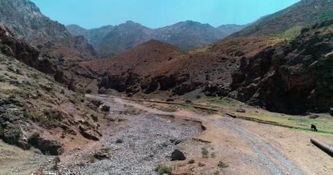 A drone flies over the bed of a dried-up river among mountains and hills Stock Footage 339784989