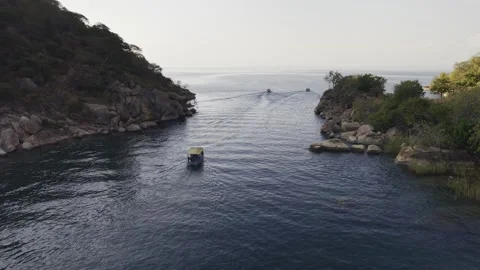 Drone flies over boat as it passes through gap between Domwe Island Stock Footage 339542128
