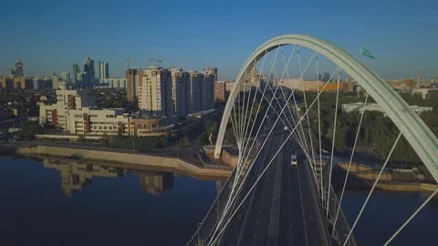 Drone flies over the bridge over the river in the summer morning. Ahead is Stock Footage 102358680