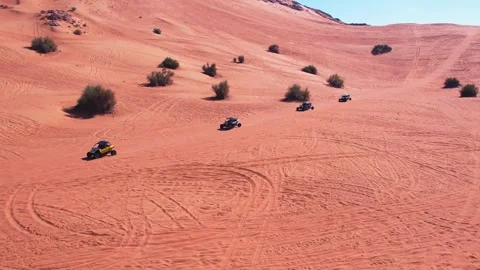 A drone flies over a buggy driving through the sand dunes of the desert Stock Footage 250931103
