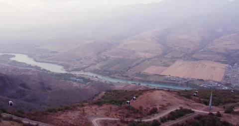 The drone flies over the cabins of the mountain cable car. At the bottom of the Stock Footage 254934305