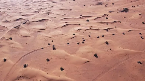 A drone flies over a caravan of buggies driving through the desert sand Stock Footage 271113718