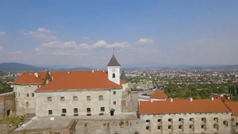 Drone flies over clock tower in medieval castle on the hill in small euro city Stock Footage 221468655