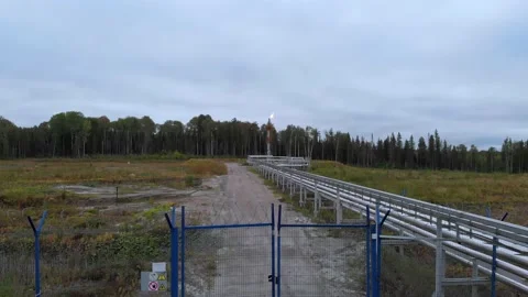The drone flies over a closed gate with a warning sign, behind the fence is a Stock Footage 172344475