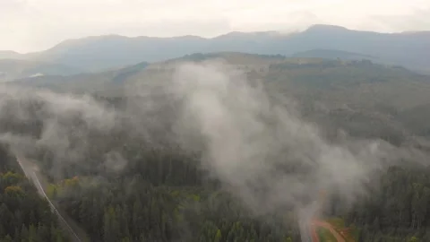 Drone flies over clouds on sunny day, summer mountain peaks in distance horizon Stock Footage 197500978