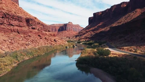 Drone Flies Over Colorado River Surrounded By Red Massive Of Rocks In Canyon Stock Footage 274489664