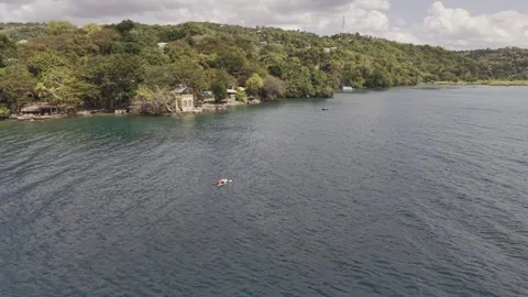 Drone flies over couple on paddle board and heads toward lakeside resort Vídeo Stock 340805862