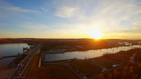 Drone flies over a dam where cars are driving at sunset. Aerial shot Stock Footage 126461444