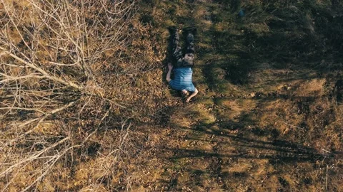 A drone flies over the dead body of a man killed on the road in a landfill aeria Stock Footage 163787107
