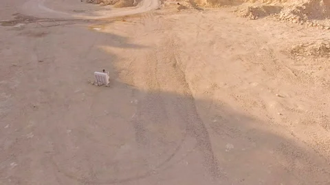 Drone flies over a deep foundation pit in which a man plays the piano. Aerial Stock Footage 94257551