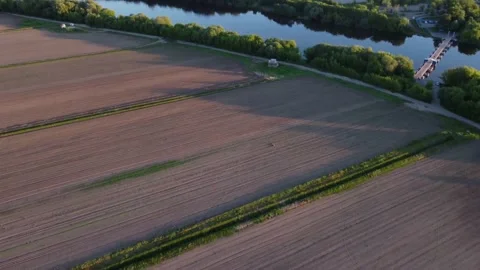 The drone flies over the field and then across the river  Stock-Footage 155884751