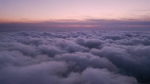 A drone flies over fluffy clouds at sunset. The drone flies through the clouds Stock Footage 254813078