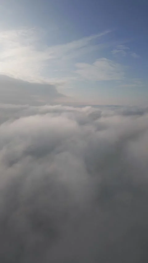 A drone flies over fluffy clouds. The drone flies through the clouds, creating a Stock Footage 258564416