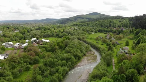 Drone flies over the forest and small houses village in mountainous area  Video stock 121082164