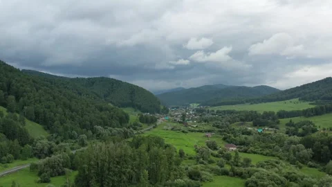 A drone flies over a forest and a small town Stock Footage 249402610