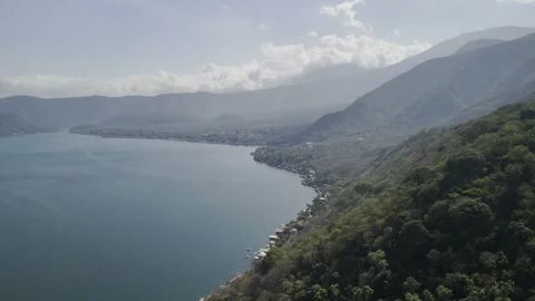Drone flies over forest on hill toward Lake Coatepeque Stock Footage 306360447