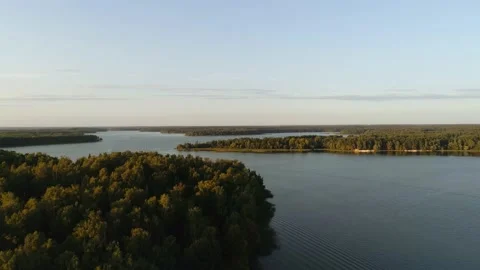 The drone flies over the forests and the river along which boats float Stock Footage 169584672