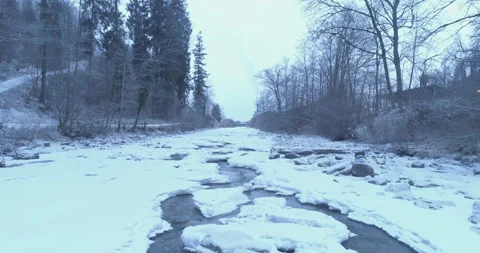 A drone flies over a frozen river in winter Stock Footage 266890129