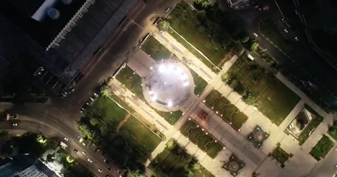 A drone flies over a giant flag in the middle of a lit city at night Stock Footage 309324004