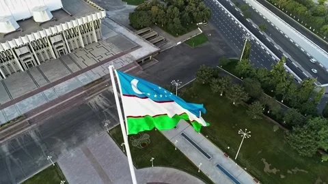 A drone flies over a giant flag in the middle of a city. Stock Footage 334656691