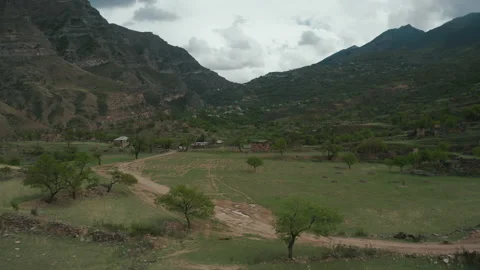 Drone flies over green fields, mountain terrain Stock Footage 165566459