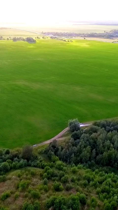 Drone flies over green fields and road during summer Stock Footage 334168820