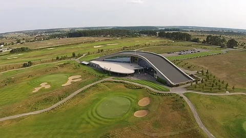 A drone flies over a green golf course with golf club building Vídeos de archivo 79744538