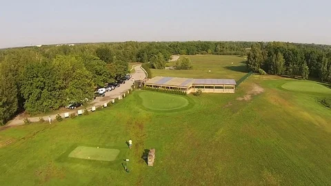 A drone flies over a green golf course with golf club building Vídeos de archivo 79851735