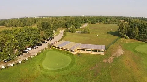 A drone flies over a green golf course with golf club building Vídeos de archivo 79852138