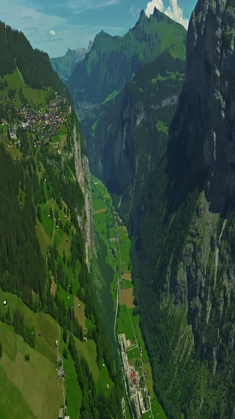 Drone flies over green picturesque valley with mountains in the background. High Video stock 311645853