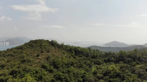 The drone flies over the hill, overlooking a small bay Stock Footage 119401359